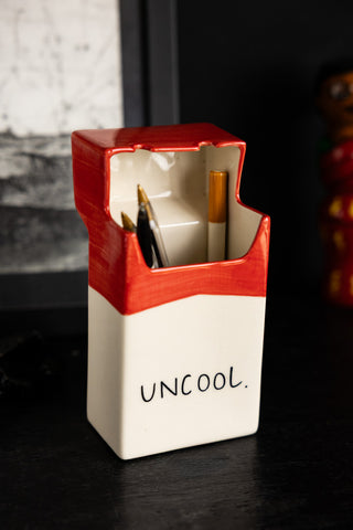 Image of the Uncool Cigarette Packet Ceramic Ornament on a desk