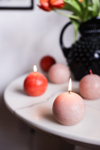 Image of the Unique Ball Candle In Rust Orange with the pink version