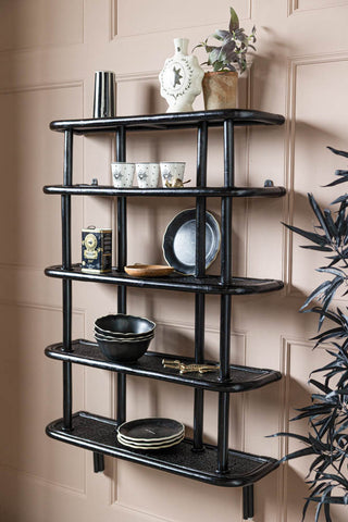 Lifestyle image of the Vintage-Inspired Black Rattan Wall Shelf