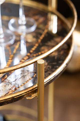 The distressed gold frame of the Vintage Palms Gold Mirrored Drinks Trolley. 