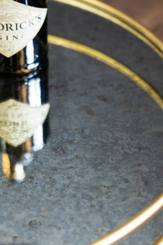 The foxed mirror on the shelf of the Vintage Palms Gold Mirrored Drinks Trolley. 