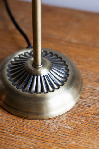 The scalloped detail and antique-gold finish on the base of the Vintage Pink Fluted Glass Table Lamp. 