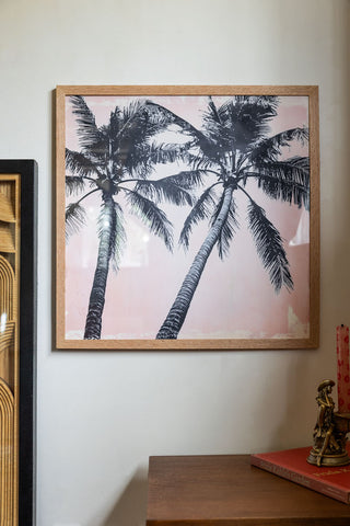 Lifestyle image of Vintage Pink Palms 50cm x 50cm Art Print in a natural frame on a light background.