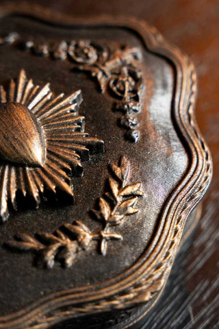 Detail of the milagro and leaf detailing on the lid of the Vintage-Style Milagro Heart Trinket Box. 
