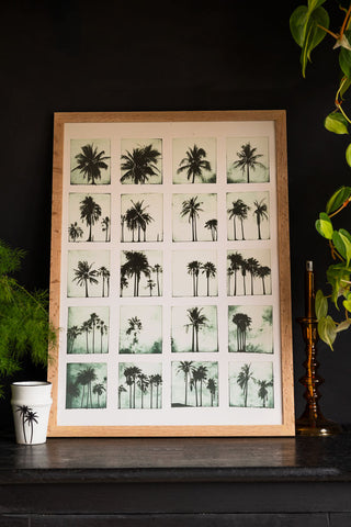 Lifestyle image of the Vintage-Style Polaroid Palms A2 Art Print in a natural frame on a dark background.