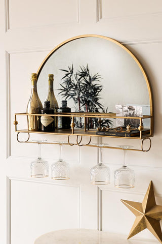 Close up image of a wall mounted bar cart with gold and mirror detail. 