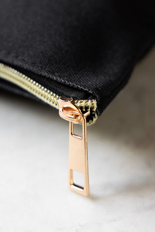 The gold zip on the Weirdo Black Canvas Pouch. 