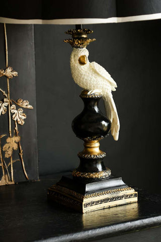 Lifestyle image of the White Parrot Table Lamp Base displayed on a black sideboard.
