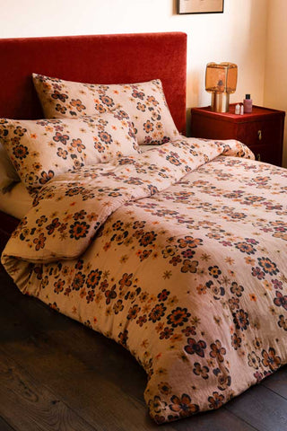 Woodstock Floral Cotton Muslin Bedding Set shown against a burnt brick velvet headboard and neutral walls.