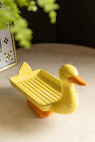 The Yellow Duck Soap Dish displayed on a marble surface.