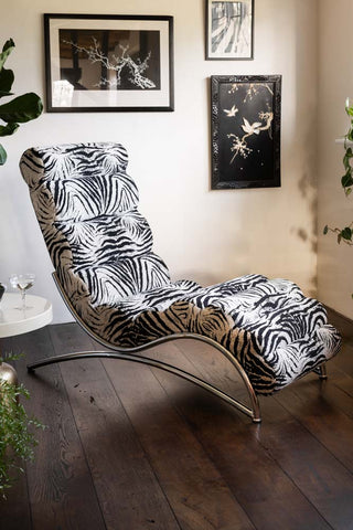 image of Zebra Print Lounger Chair shown in a neutral space with monochrome artwork on the walls. 