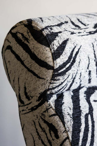 Close up detail of the curved top corner of the Zebra Print Lounger Chair. 