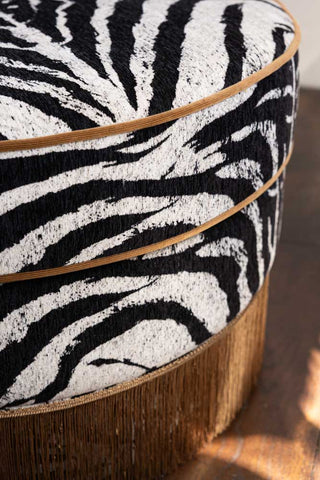 A close up shot of the curve of the seat of the Zebra Print Tassel Swivel Chair.