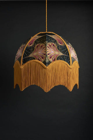 An image of a ceiling light with long amber fringing at the bottom and a lino cut inspired printed shade.. 