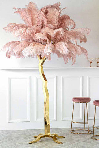 A magnificent floor lamp with a gold tree like base and fabulous pink feathered top. Two pink and gold bar stools poke in on the right hand side.