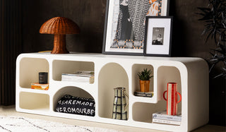 The Large White Alcove Sideboard / TV Unit styled with various home accessories, with a lamp and art prints on the top.