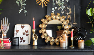 Lifestyle image of various gifts themed around Valentine's Day arranged together on a black sideboard. 