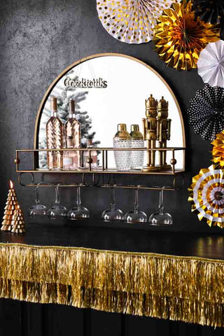 Bold bar shelf with mirror styled with glassware, wine and gin, surrounded by gold christmas decorations.