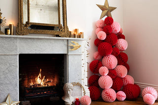 lifestyle of the red and pink honeycomb balls styled to create a christmas tree