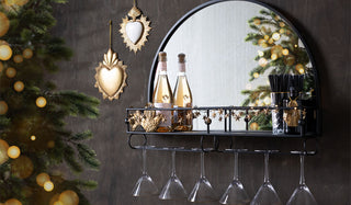 A bar mirror styled on the wall with various accessories.