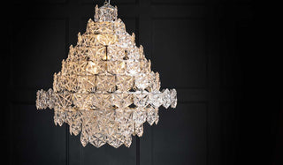 Image of the incredible and showstopping glass chandelier turned on. The chandelier glass is layered to create an incredible tiered effect.