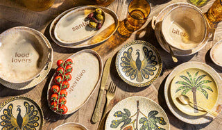 Collection of decorative plates with various designs and text on a wooden surface.
