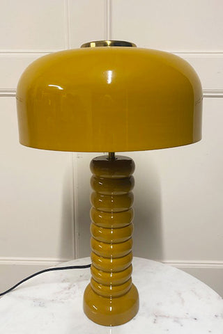 Side view of the mustard lamp on a white table. 