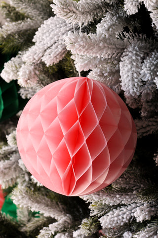 Detail of the pink honeycomb ball decoration on a frosted tree.
