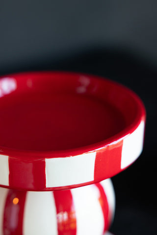 Close-up of the top of a red and white striped candle holder.