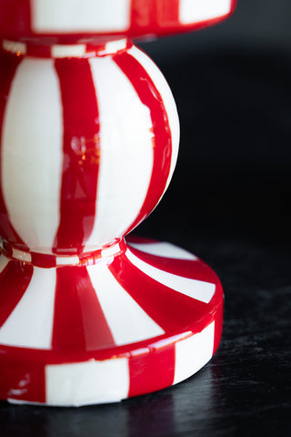 Close-up of the base of a red and white striped candle holder.