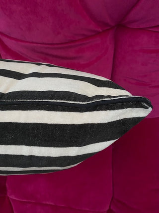 The Monochrome Striped Velvet Cushion Cover against a red background.