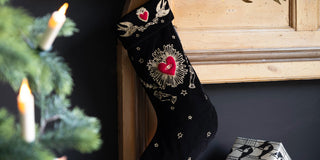 A black and red milagro embroidered christmas stocking