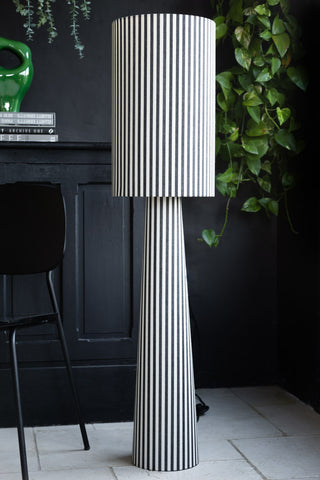 Lifestyle image of the Black & White Stripe Floor Lamp with a black cabinet