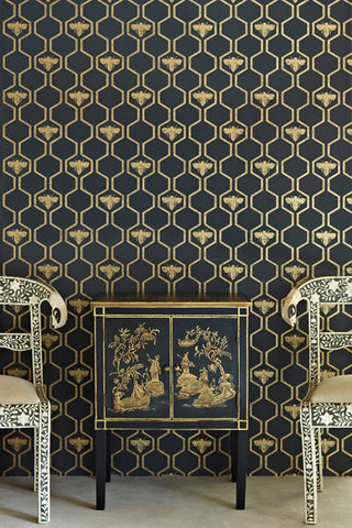 Detail image of Barneby Gates Honey Bees Wallpaper - Gold on Charcoal with black and gold cabinet and two chairs