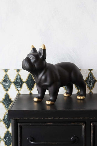 lifestyle image of Black Ceramic French Bulldog Ornament By Young & Battaglia on black desk with patterned wallpaper background