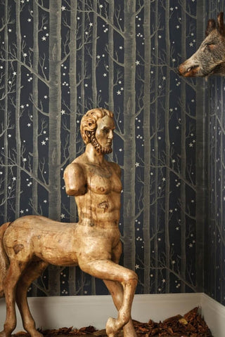 lifestyle image of cole & son whimsical collection - colour woods & stars wallpaper - 3 colours available with gold centaur statue and donkey head on wall