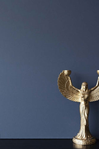 Wall painted in blue 'Payne's Grey' paint, behind a winged decorative statue on a tabletop. 