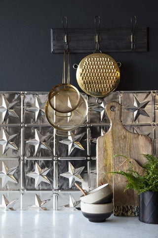 A close up image  of Rockett St George tin tile in a star shape design in a kitchen scene. 