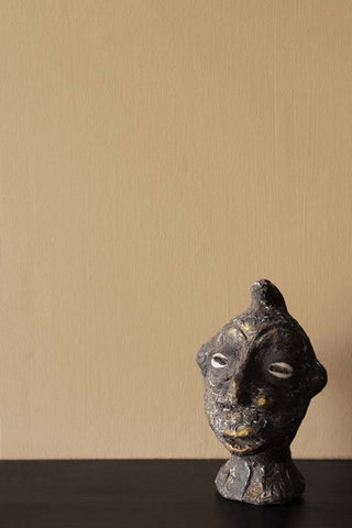 Close up image of a statue of a mans head photographed in front of a wall painted in Cloisters, a paint that is a warm beige colour. 