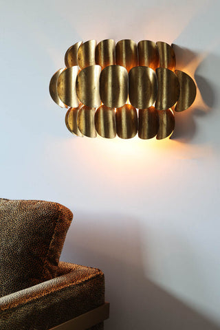 Lifestyle image of the Antique Brass Curve Disc Wall Light