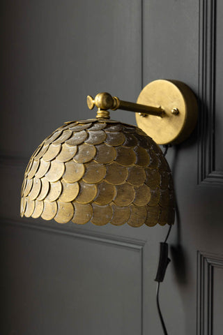 Lifestyle image of the Antique Brass Scalloped Plug In Wall Light