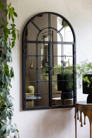 Image of the Black Metal Arch Window Pane Indoor/Outdoor Mirror With Opening Doors inside hanging on the wall