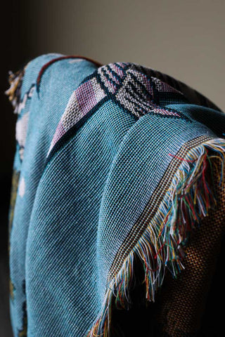 Image of the Denim & Bone Blue Loved Woven Cotton Throw draped on a chair