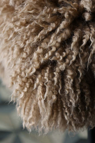 Close-up image of the curl in the Curly Sheepskin Rug In Butterscotch