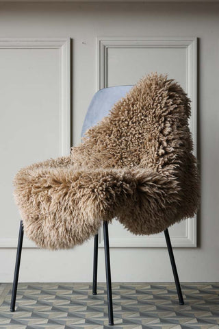 Image of the Curly Sheepskin Rug In Butterscotch on a chair