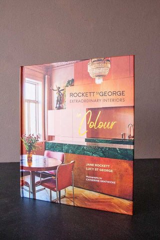 Lifestyle image of the front cover of the Extraordinary Interiors in Colour by Jane Rockett & Lucy St George standing up