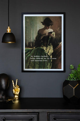 Lifestyle image of the Framed My Hobbies Include... Art Print on a dark wall