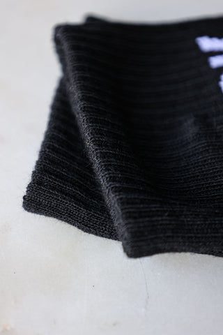 Detailed image of the cuff of the Fuck Off Black Socks. 