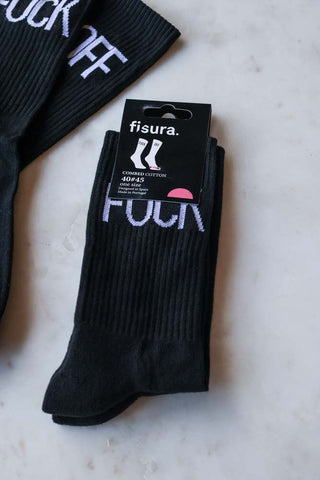 Lifestyle image of the Fuck Off Black Socks in its packaging. 