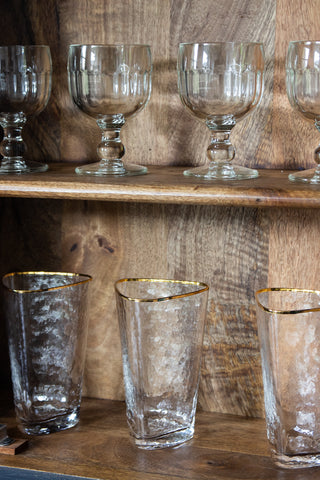 Image of the Organic Highball Glass With Gold Rim on a shelf with the Golblet Glass